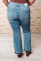 Person wearing blue jeans with a brick wall background
