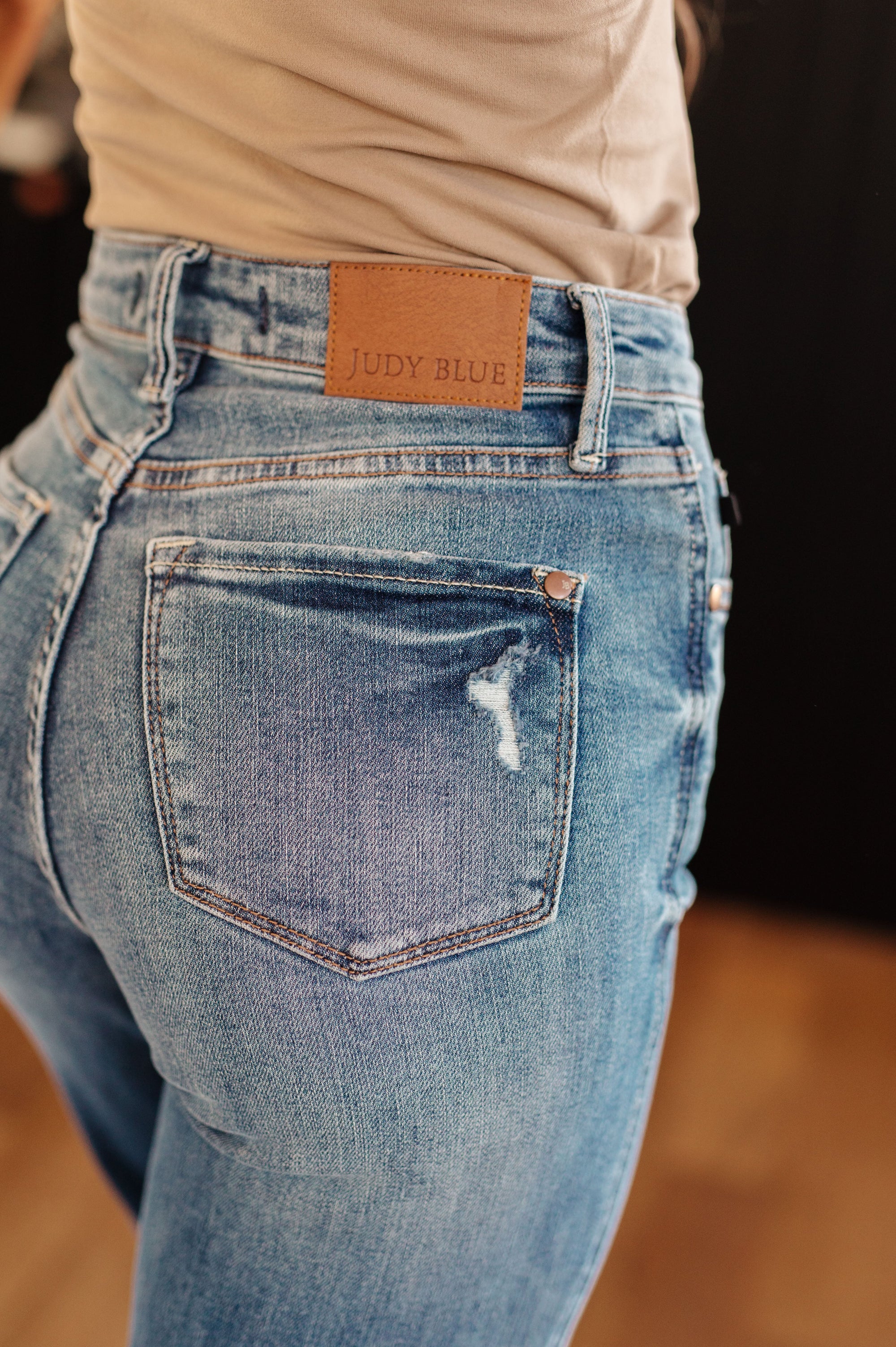 Close-up of blue jeans with a brand label on the back pocket, blurred background
