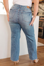 Person wearing blue jeans standing in a kitchen.