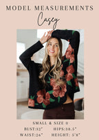 Woman wearing a floral sweater with model measurements displayed.