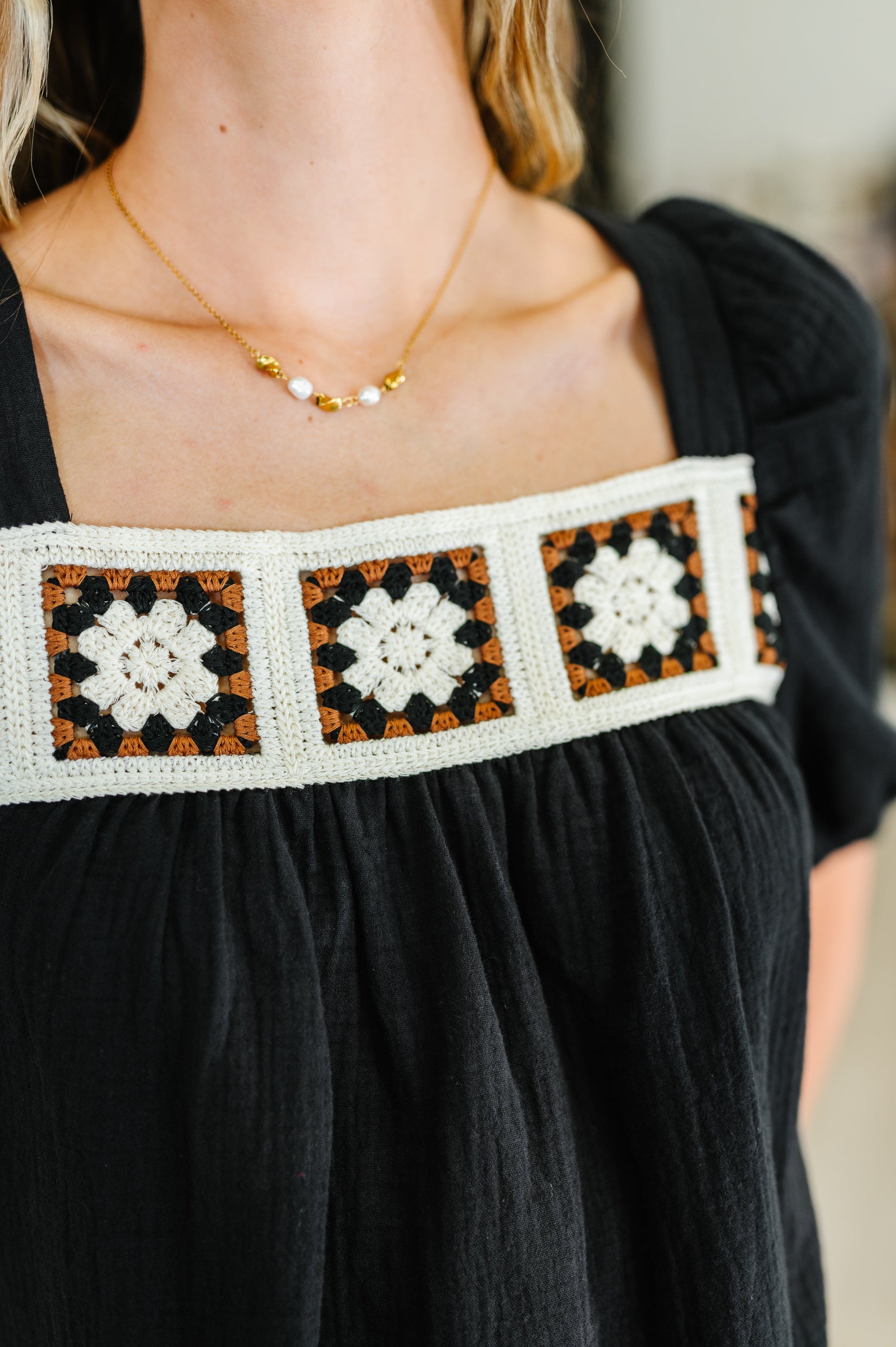 Black dress with a patterned white, orange, and black neckline