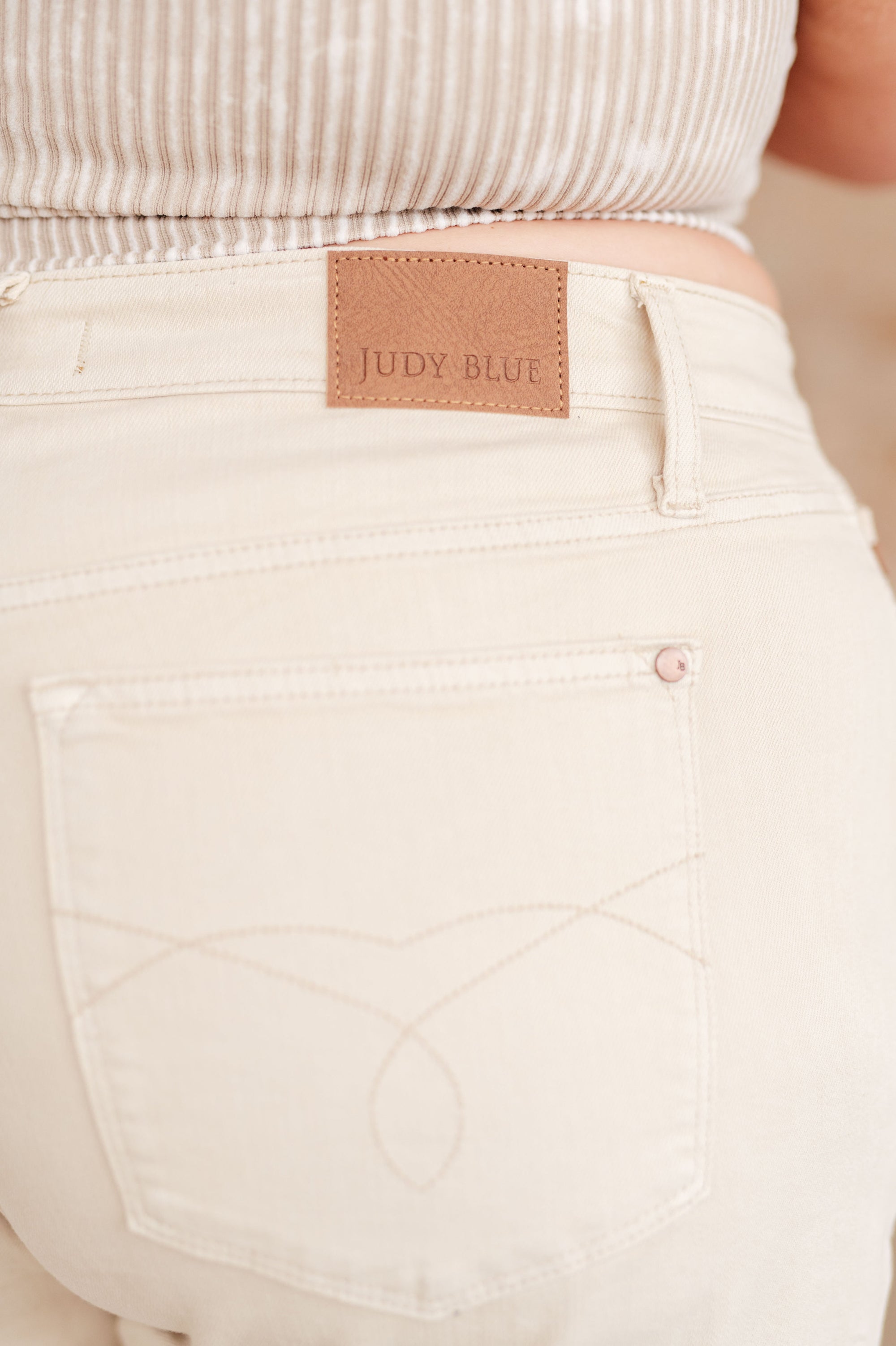 Beige pants with a Judy Blue label on a blurred background