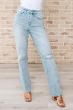 Light blue jeans worn by a person against a brick wall.