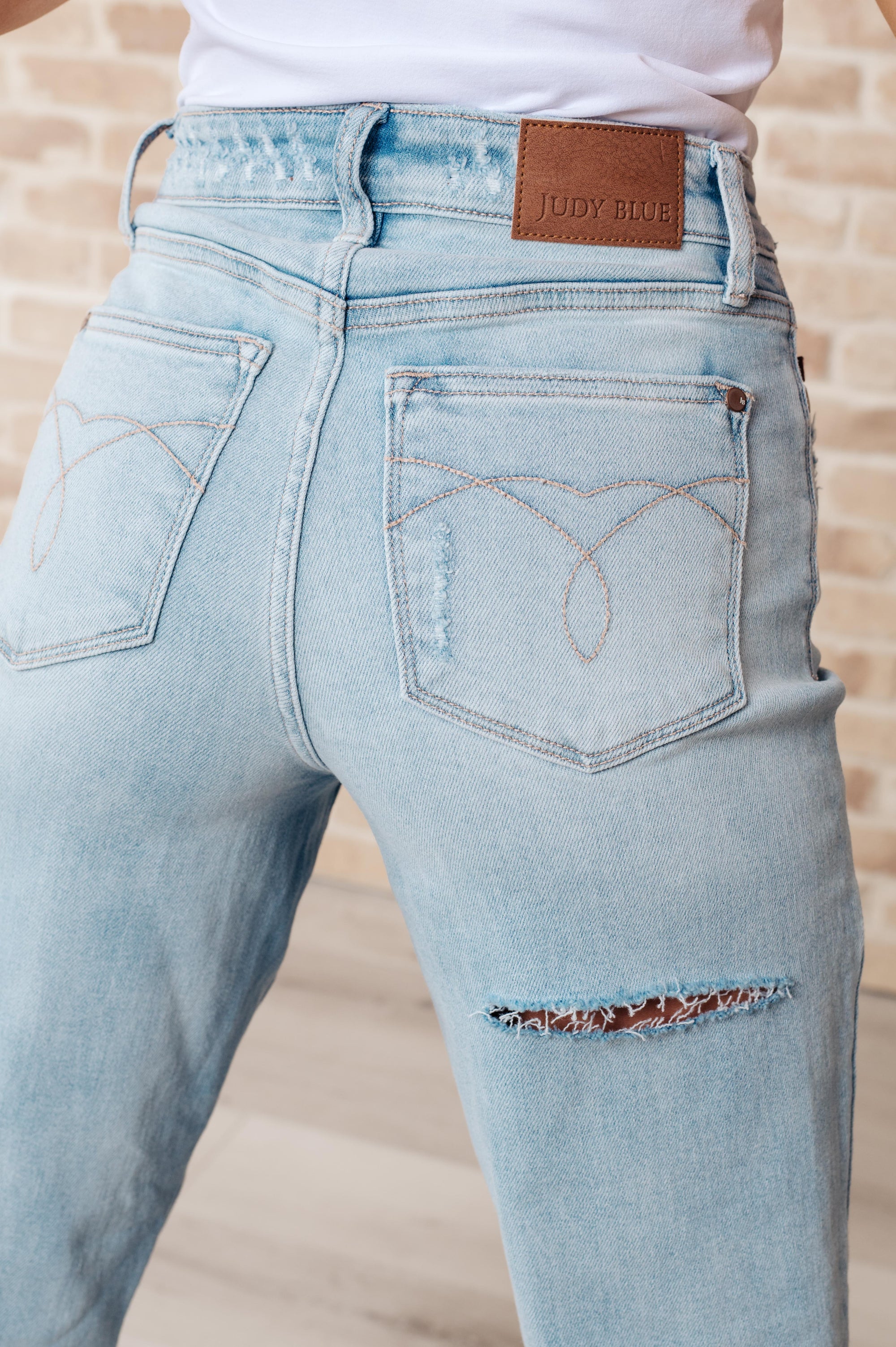 Light blue jeans with a brand label on a neutral background