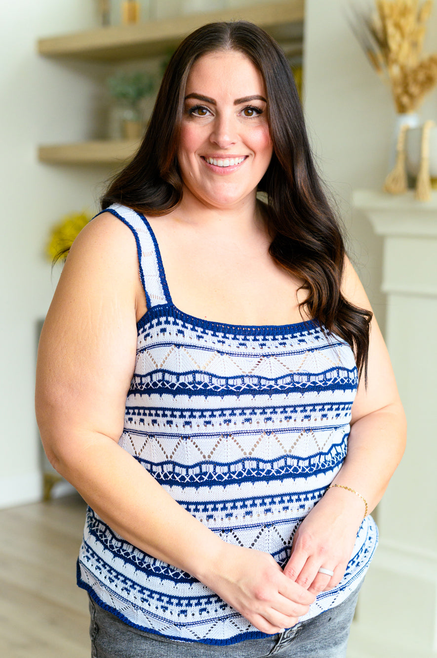 Woman wearing a blue and white patterned tank top in a home setting.