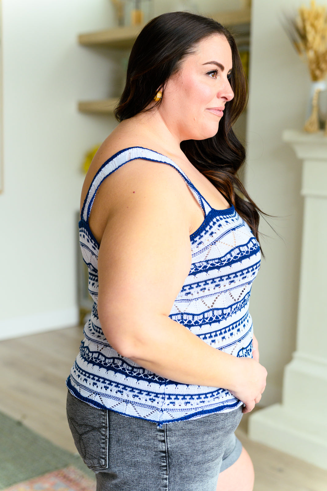 Woman wearing a blue and white patterned tank top in a home setting