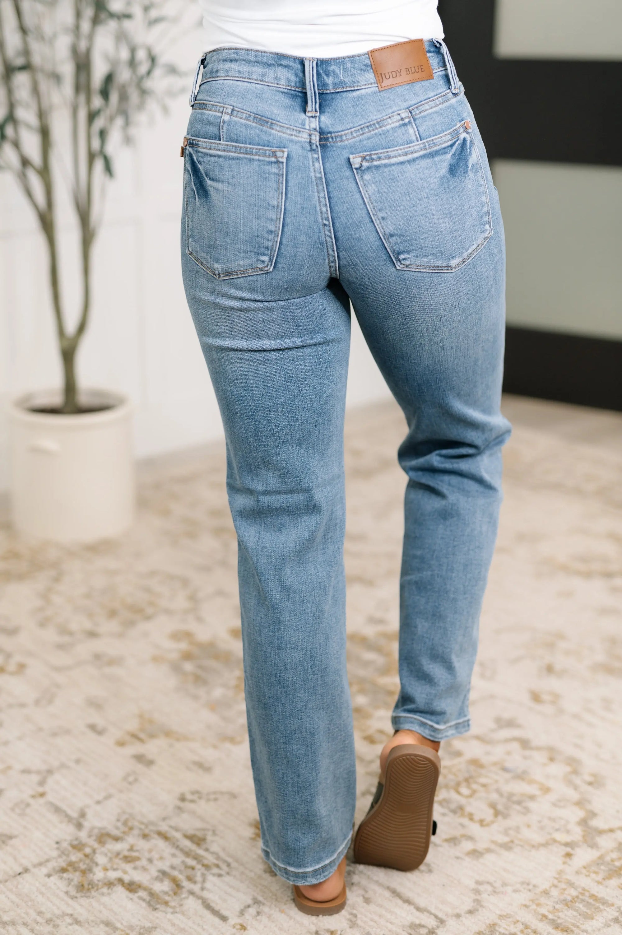 Light blue jeans worn by a person on a neutral background